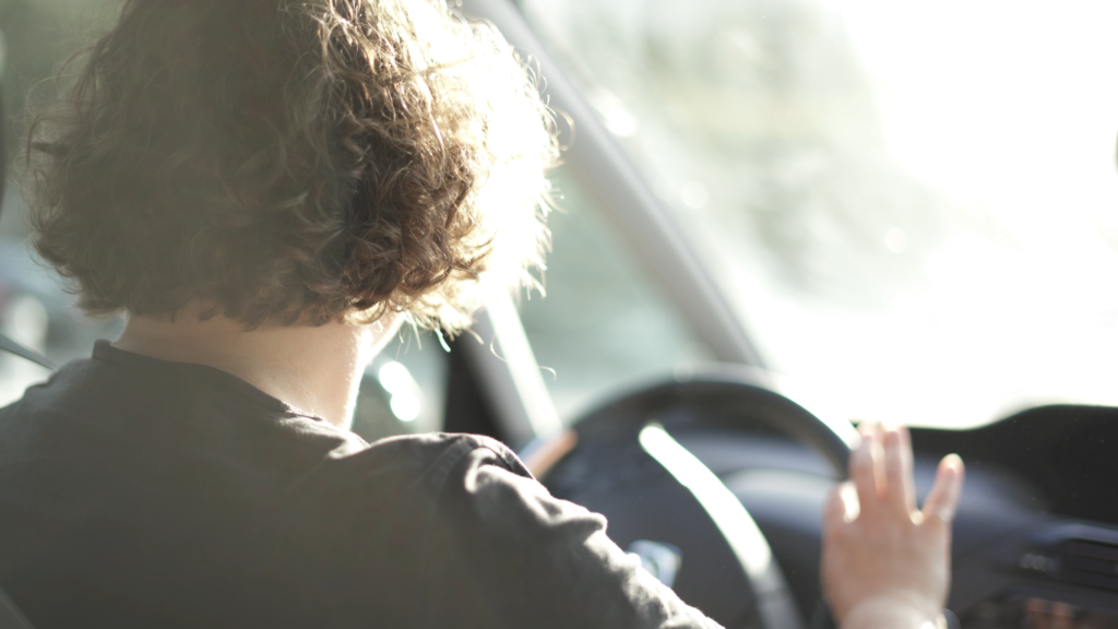 femme de dos au volant d'une voiture