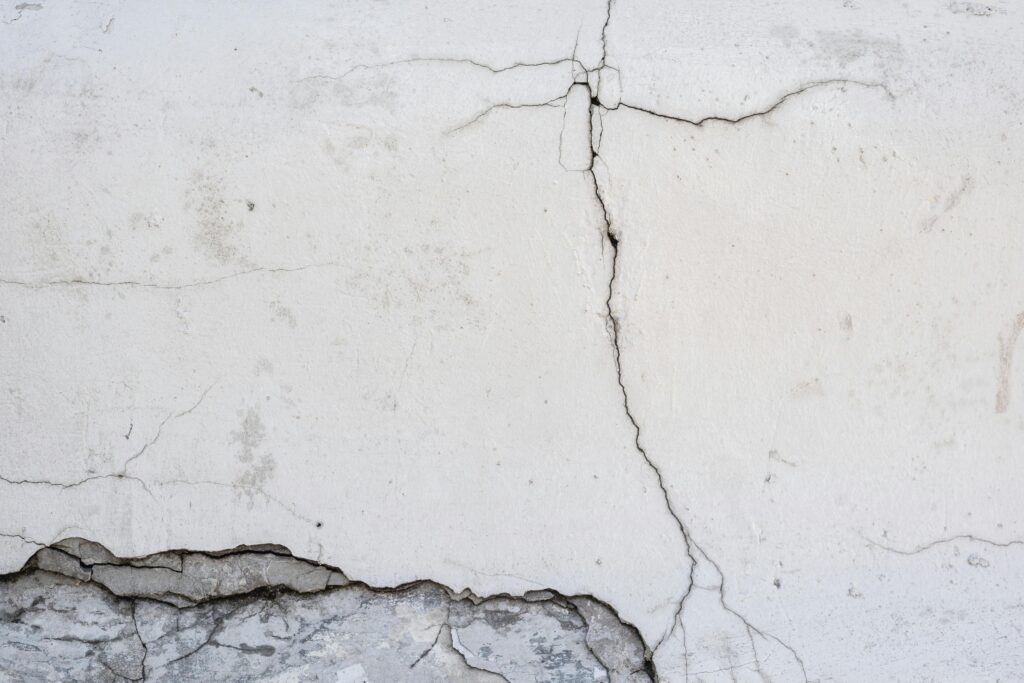 fissures sur mur en béton blanc